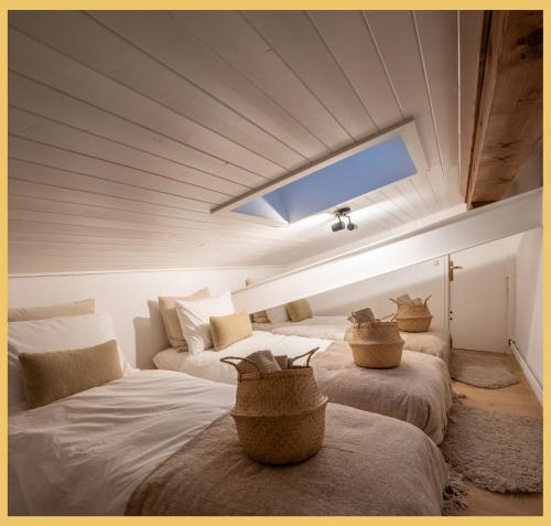 ein Zimmer mit 2 Betten und Körben darauf in der Unterkunft Le Cocon Alpin I Megève in Megève