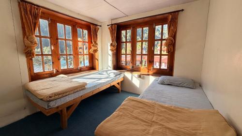 a room with two beds and two windows at Phakding Camp One Lodge in Phakding