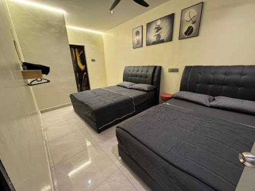 Un dormitorio con dos camas y una silla. en Ipoh Spacious Comfort Staycation Homefeel free WIFI TK9, en Ipoh