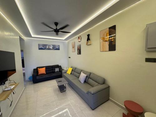 a living room with a couch and a ceiling fan at Spacious Comfort Staycation Homefeel free WIFI TK9 in Ipoh