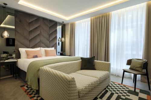 a bedroom with a bed and a chair and a desk at The Wellington Glasgow by Adina in Glasgow