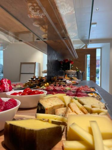 een buffet met kaas en andere voedingsmiddelen op tafel bij Gemmi Hotel & Spa in Kandersteg