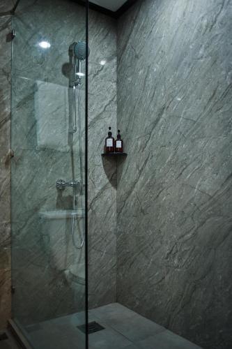 a bathroom with a shower with a glass door at Le Charme Vientiane Hotel in Vientiane