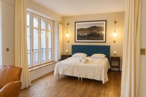 een slaapkamer met een bed en een schilderij aan de muur bij Loft me - Entre art deco et loft à l'americaine in Périgueux