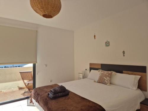 a bedroom with a large bed and a balcony at Casa en Cotillo Lagos with Wifi & Netflix in Cotillo