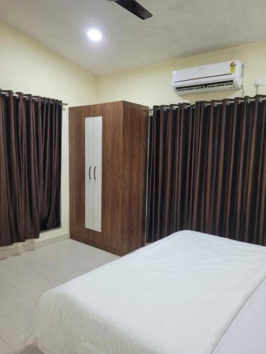 1 Schlafzimmer mit einem Bett und Klimaanlage in der Unterkunft Zenzi Stays 11 BHK With 2 Pools in Khandāla