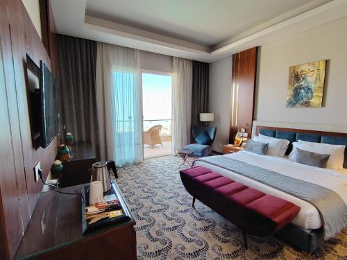 Una habitación de hotel con una cama grande y un televisor. en Tolip Resort El Galala Heights, en Ain Sokhna