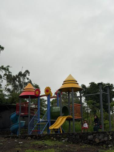 Un parque infantil con dos toboganes y dos niños en él. en NZ Villa Guesthouse Aesthetic Batu, en Malang
