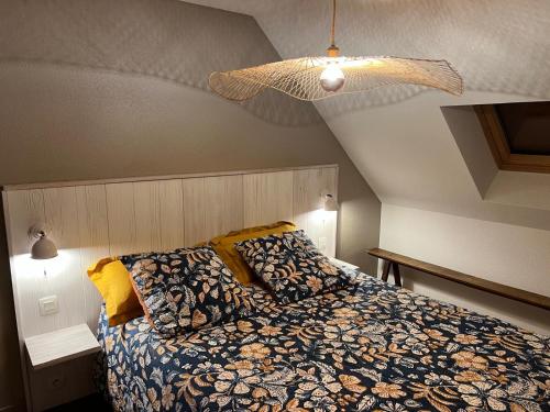 una camera da letto con un letto e un soffitto di Appartement duplex vue mer ad Audierne