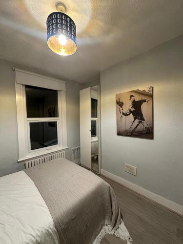 a bedroom with a bed and a painting on the wall at 1 bedroom flat 15 minutes from Oxford Circus in London