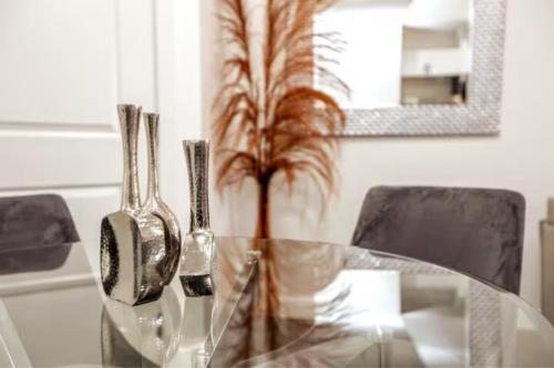 a glass table with a vase with a plant on it at Chic Suite - Long Stays - King Bed - Fireplace & WiFi in Edmonton
