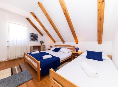 2 letti in una camera con travi in legno di Lovinac Spa by Režek a Lovinac