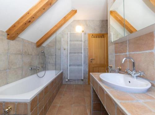 un bagno con una grande vasca e un lavandino di Lovinac Spa by Režek a Lovinac