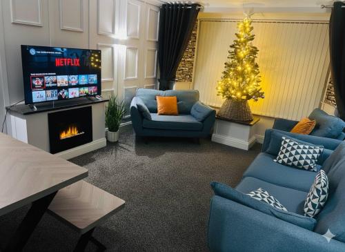 een woonkamer met een kerstboom en een tv bij Churchill Apartment- 4 Beds- Free Parking- Near NEC BHX & HS2 in Coleshill