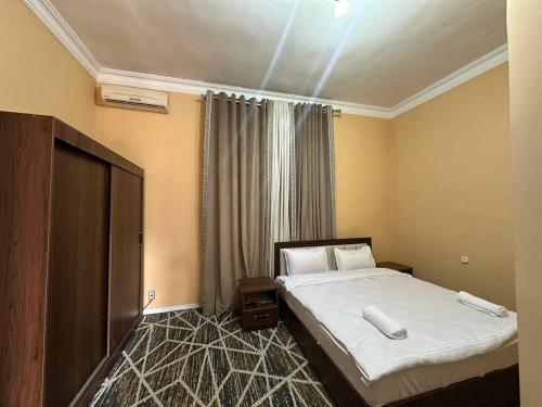 サマルカンドにあるHotel Global Starのベッドとテレビがあるホテルの部屋