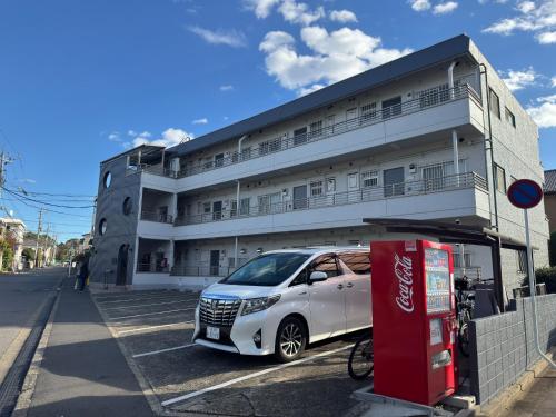 a white van parked in a parking lot in front of a building at HYGGE HOUSE Tabibitonoie - Vacation STAY 61161v in Kashiwa