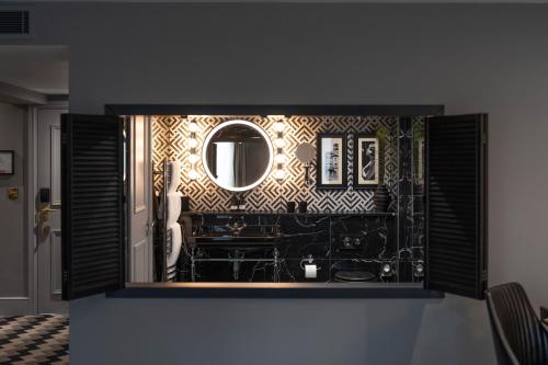 a bathroom with a mirror and a sink at Hotel Gotham Newcastle in Newcastle upon Tyne