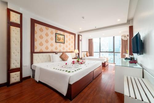 a hotel room with a large bed with flowers on it at Thai Ha Hotel in Ha Long