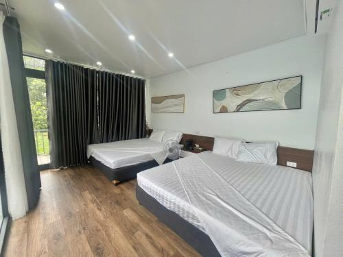 a hotel room with two beds and a window at Mường Dy Retreat 2 in Ba Vì