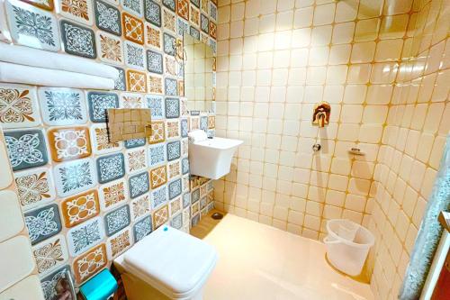 Hotel Ganga Ashoka- 100m from Ganga Ghat في ريشيكيش: حمام مع مرحاض ومغسلة ودش