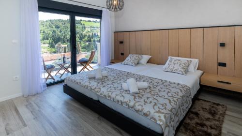 a bedroom with a large bed and a balcony at Villa Tea - Kremena by Villas Guide in Blace