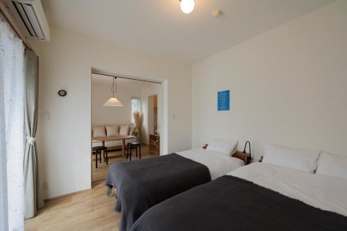 東京にあるThe Apartment Hotel 恵比寿1のベッド2台とダイニングルームのある寝室