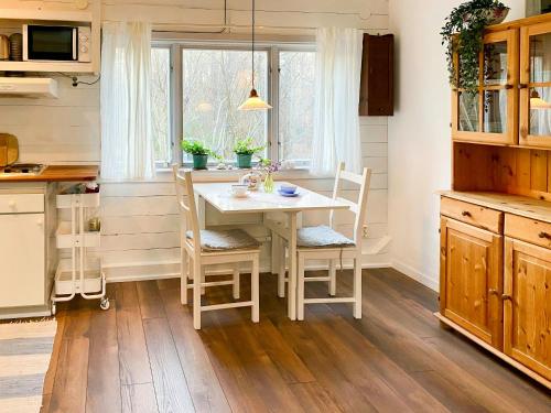Cottage By The Sea On Djurö في Djurhamn: مطبخ مع طاولة وكراسي ونافذة
