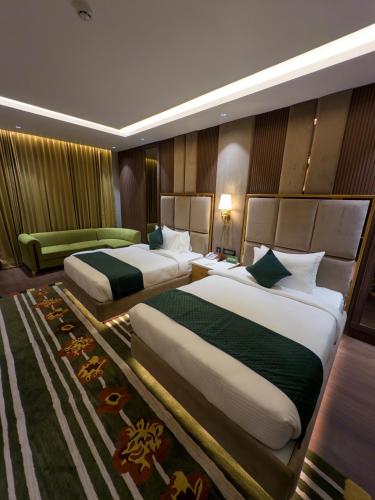 a hotel room with two beds and a couch at Comfort Inn Vindhyan, Vindhyachal in Mirzāpur