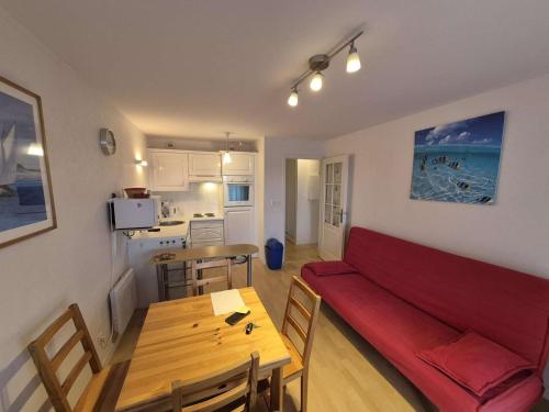 a living room with a red couch and a table at Confortable appartement 4 personnes avec balcon, parking à Stella Plage - FR-1-236-173 in Stella-Plage