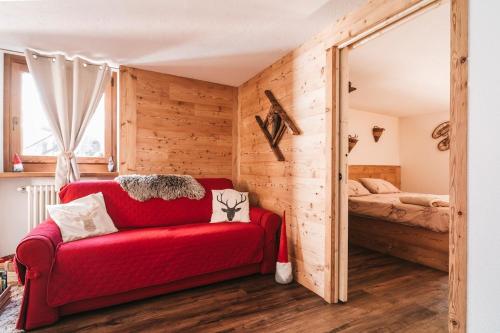 a red couch in a room with a bedroom at Lo Chalet Du Village in Chambave