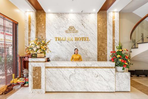 a man sitting at a counter in a hotel lobby at Thai Ha Hotel in Ha Long