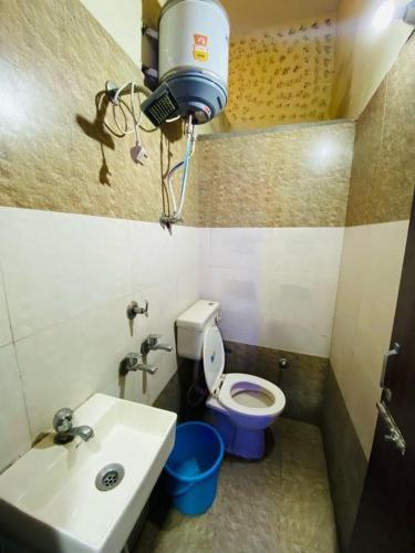 a small bathroom with a toilet and a sink at RS Hotel in Amritsar