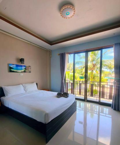 a bedroom with a bed and a large window at The Coco Grand Chalet in Satun