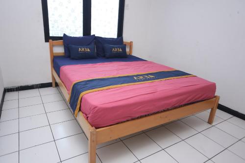 a bed with a pink blanket and blue pillows on it at Villa Gunung By ARBA in Pasakon 1