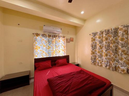 ein Schlafzimmer mit einem roten Bett und einem Fenster in der Unterkunft Studio 307 Signature Suite in Deoghar