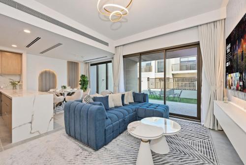 a living room with a blue couch and a table at Golden Stays - Luxe 4BR Villa Family-Friendly and Fully Equipped in Dubai