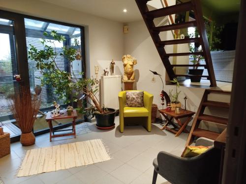 B&B Aquavert في تورناي: غرفة معيشة مع درج وكرسي أصفر