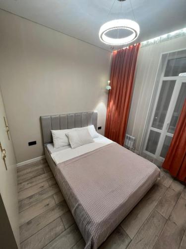 a bedroom with a bed and a large window at Инжу Сити in Karagandy