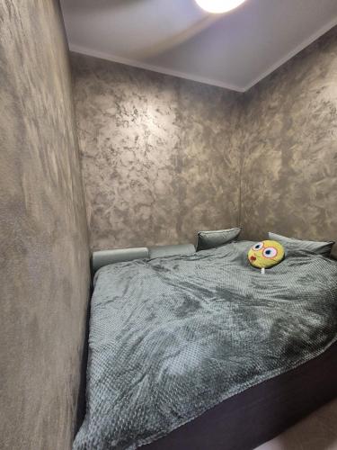 ein Schlafzimmer mit einem Bett, auf dem ein Kissen mit einem Smiley-Gesicht liegt in der Unterkunft XTN house AIRPORT with PARKING in Cluj-Napoca