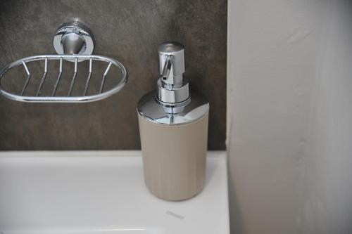 a soap dispenser sitting on top of a bathroom sink at Sentlhaga 1 Bed Self Catering Apartment, Sarona City,Habitat Kappa, Gaborone in Gaborone