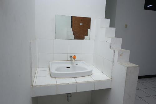 a white sink in a white tiled bathroom at Villa Gunung By ARBA in Pasakon 1