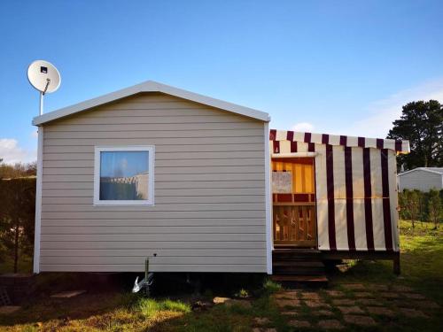 a small house with a gambrel roof and a window at davorel mobil home in Les Mathes