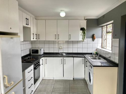 BelharUnit 1, TraversHub Sleeps 6 Self-Catering Group Belhar, CT的带白色橱柜和水槽的白色厨房