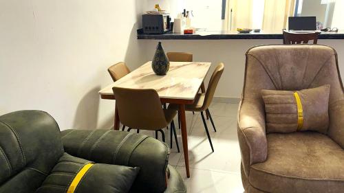 a living room with a table and a chair at Le Prestige Appartement à Oloumi in Libreville