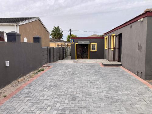 Unit 1, TraversHub Sleeps 6 Self-Catering Group Belhar, CT في Belhar: ممر فارغ امام مبنى