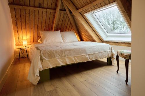 a bedroom with a bed and a window in a attic at Appartement B Rosita in Twisk