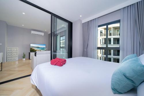 a bedroom with a white bed and a large window at The Title Legendary D-605 1 BR Bangtao Beach in Bang Tao Beach