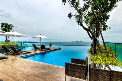 - une piscine dans un complexe avec des chaises et des parasols dans l'établissement Wongamat Tower Condominium, à Pattaya (nord)