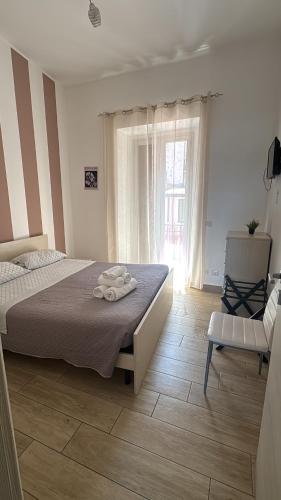 una camera da letto con un letto, una sedia e una finestra di Le Mirage boutique II a Reggio di Calabria