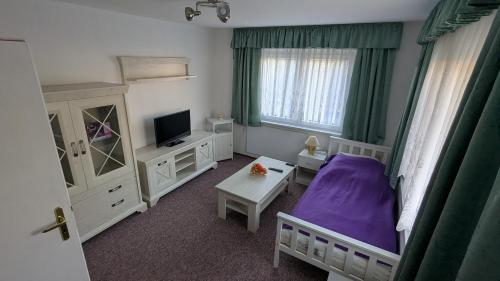 a bedroom with a purple bed and a table at Ferienwohnung Bergstraße Hammermühle in Bad Düben